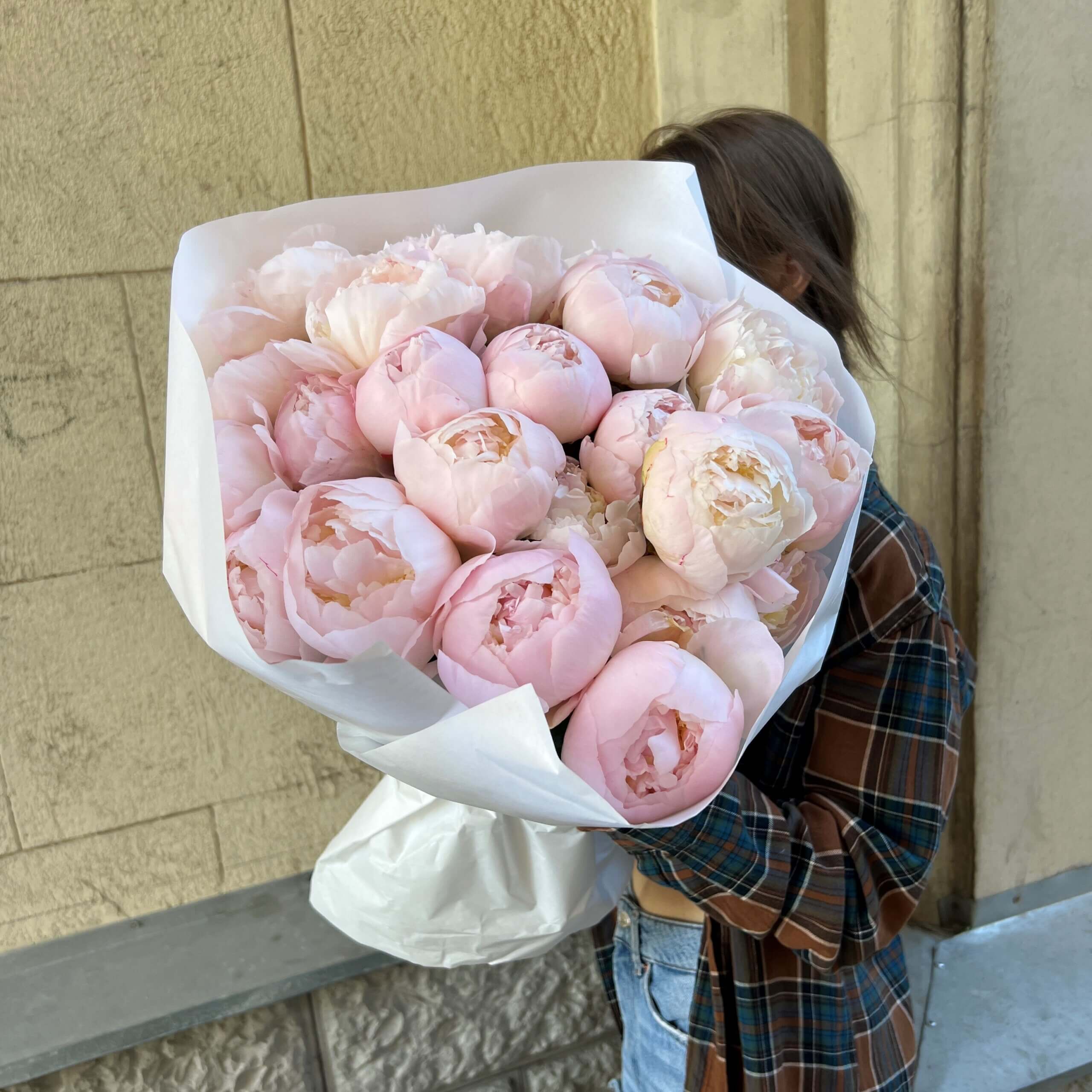 Букет из 25 нежных розовых пионов в белом оформлении